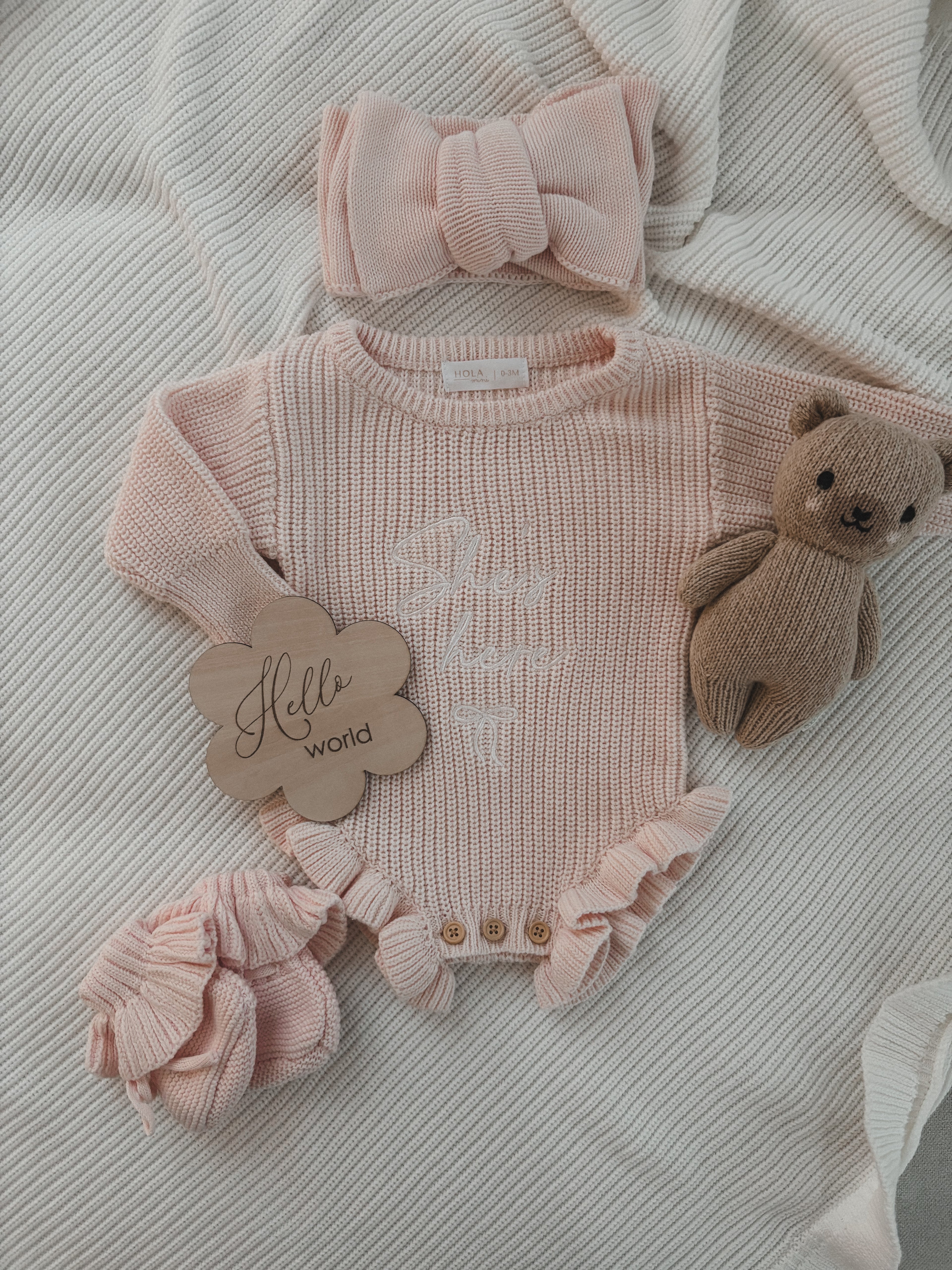 Rüschenstrampler „She‘s here“ in Puderrosa | + Haarband & Strickschühchen