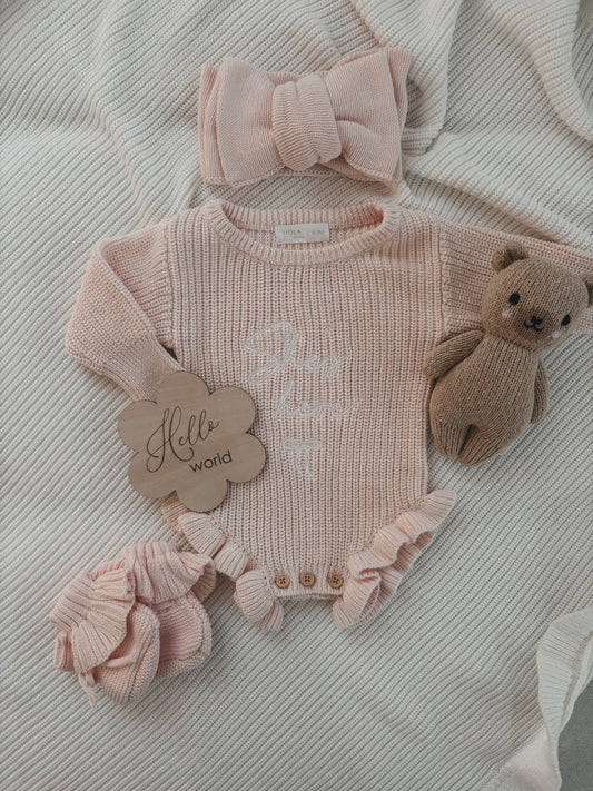 Rüschenstrampler „She‘s here“ in Puderrosa | + Haarband & Strickschühchen