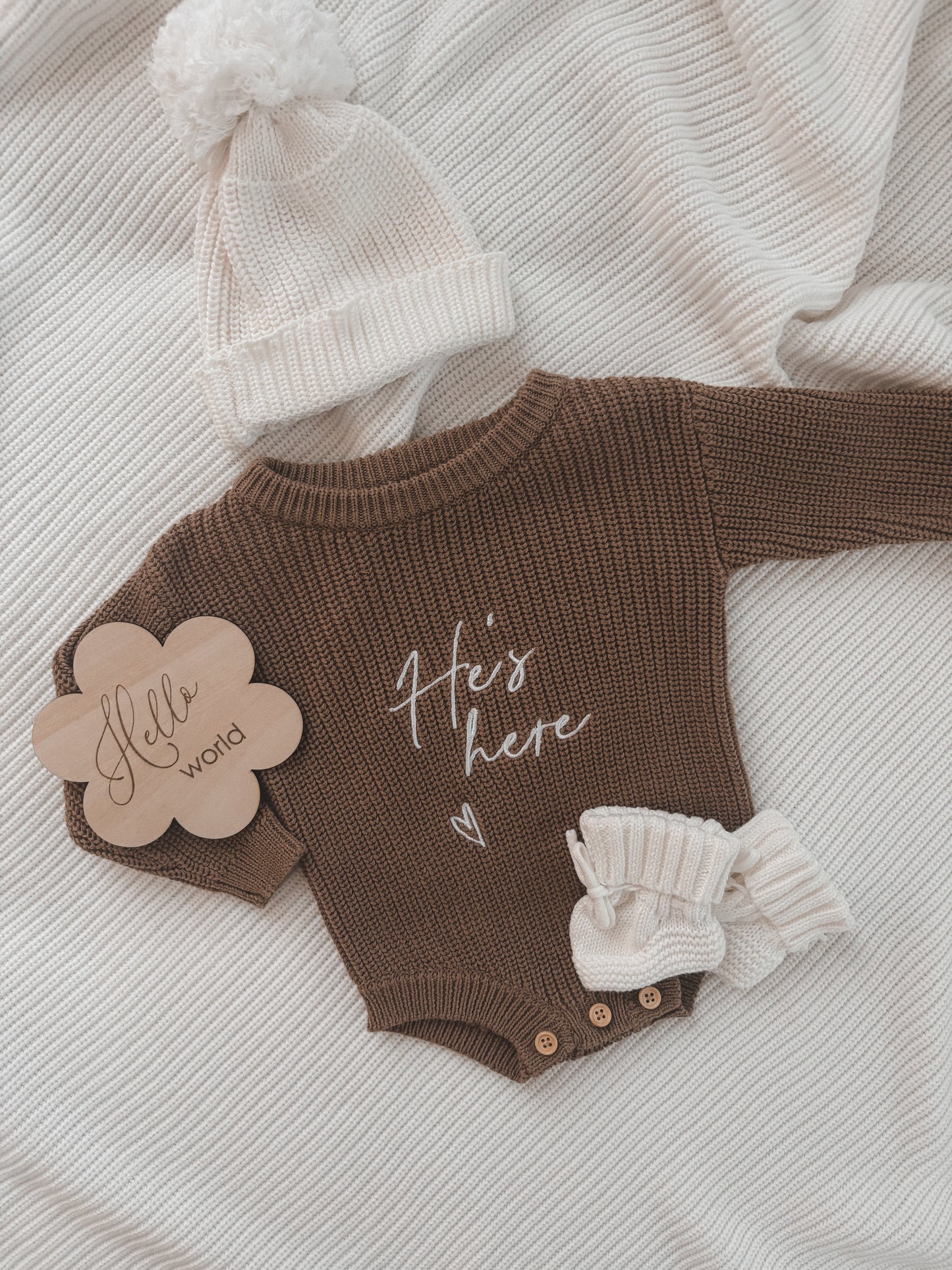 Strick-Strampler „He‘s here“ in Teddybraun | + Strickmütze und Strickschühchen in Weiß